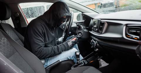 Autodiefstal; autodief zit in een auto 